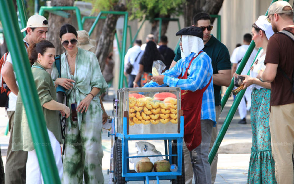 Tourists on Maha Rat Road in Phra Nakhon district of Bangkok buy fruit on April 25, 2024.