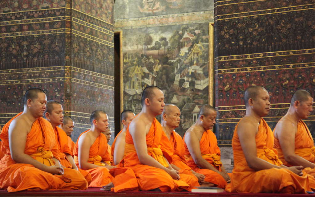 A group of Buddhist monks meditating in a temple.
